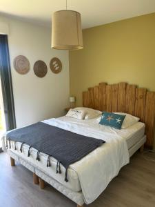 a bedroom with a large bed with a wooden headboard at Le jardin de la mer in Wierre-Effroy