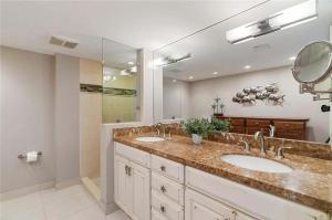 a bathroom with two sinks and a large mirror at Islamorada Oceanfront Luxury Living in Islamorada