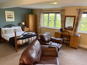 a bedroom with a bed and a couch and a desk at Ganton Greyhound Hotel in Ganton