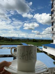 a coffee cup sitting on a plate on a balcony at Apartahotel Paraíso Cafetero Guaduales del café 401B in Montenegro