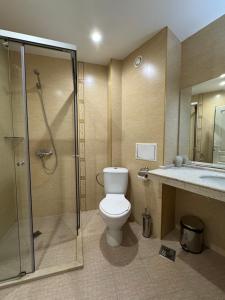 a bathroom with a toilet and a shower and a sink at Sun Boutique Pomorie in Pomorie