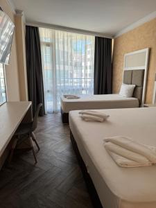 a hotel room with two beds and a desk at Sun Boutique Pomorie in Pomorie