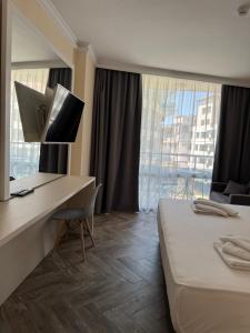 a hotel room with a desk and a bed and a window at Sun Boutique Pomorie in Pomorie
