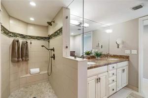 a bathroom with a shower and two sinks and a mirror at Islamorada Oceanfront Luxury Living in Islamorada +1 photo