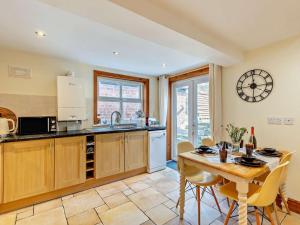 a kitchen with a table and a clock on the wall at 2 Bed in Kelsall oc-94445 in Kelsall +18 photos