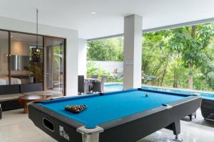 a pool table in a room with a swimming pool at Hikari Hill View Villa 7 Bedrooms With a Private Swimming Pool and a Billiard Table in Bandung