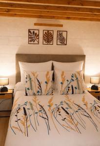 a bedroom with a bed with a comforter and pillows at Gîtes Hydra Charme et Nature proche Honfleur en Normandie in Conteville