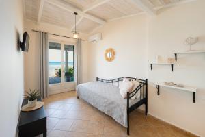 a bedroom with a bed and a view of the ocean at Garden Studios in Alykes