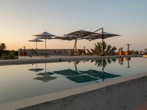 a swimming pool with umbrellas and tables and chairs at Casa Talá by Lumina in Puerto Escondido +77 photos