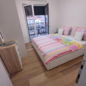a bedroom with a large bed and a table at Apartman Sunce in Posušje