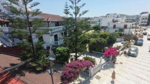 a woman walking down a city street with pink flowers at Garden Villa Veli in Ksamil