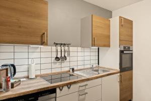 a kitchen with white appliances and wooden cabinets at Modo Apartment in Erkelenz mit Sauna Pool in Erkelenz