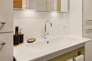 a white kitchen with a sink and a mirror at Modo Apartment in Erkelenz mit Sauna Pool in Erkelenz +11 photos