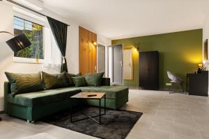 a living room with a green couch and a table at Modo Apartment in Erkelenz mit Sauna Pool in Erkelenz