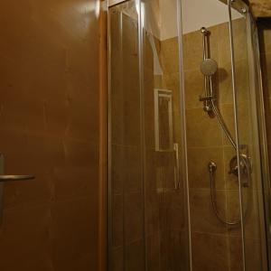 a shower stall with a glass door with a shower at Stanza Cuori Malga Ciauta in Villanova