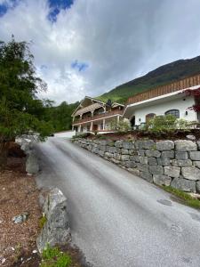 a road in front of a building with a stone wall at Charming view in Olden
