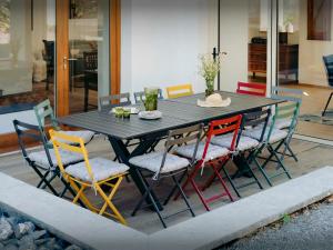a black table with colorful chairs around it at Villa Le Cep - OVO Network in Menthon-Saint-Bernard
