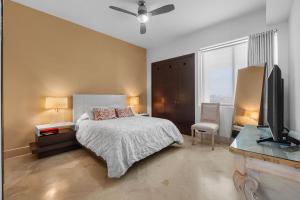 a bedroom with a bed and a flat screen tv at Luxury Beach Condo with Resort Access Vidanta in Nuevo Vallarta +27 photos