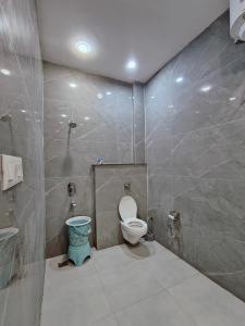 a bathroom with a toilet and a tiled wall at Hotel KR Near Golden Temple in Amritsar +35 photos