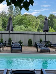 a group of chairs and umbrellas next to a swimming pool at Tysha House in Ternopil