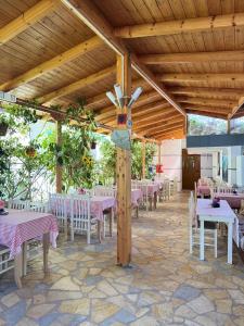 a dining room with tables and chairs and a wooden ceiling at Garden Villa Veli in Ksamil +36 photos