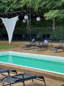 a swimming pool with chairs and a tent at Tysha House in Ternopil