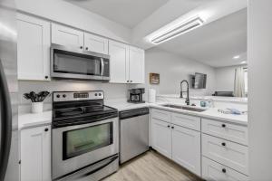 a white kitchen with a stove and a microwave at Indoor/Outdoor Pools!! Hot Tub! Steam Room! Sauna! in Osage Beach