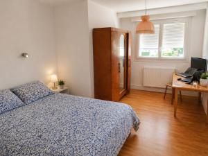 a bedroom with a bed and a desk with a laptop at Ecolocs Caen Beuville in Caen