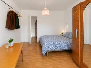 a bedroom with a bed and a wooden floor at Ecolocs Caen Beuville in Caen