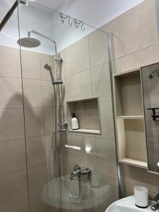 a shower with a glass door in a bathroom at City Centre Rooms 4R in Shkodër