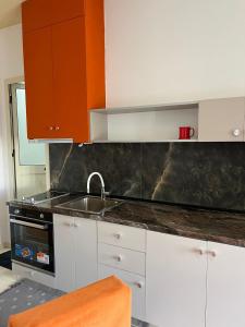 a kitchen with a sink and an orange cabinet at City Centre Rooms 4R in Shkodër +55 photos