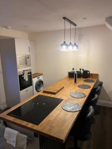 a kitchen with a long wooden table with a stove at Serene escape in Cleator Moor +1 photo