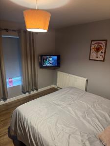 a bedroom with a bed and a flat screen tv at Serene escape in Cleator Moor