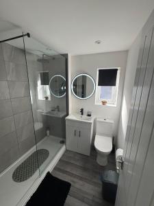 a bathroom with a shower and a toilet and a sink at Serene escape in Cleator Moor