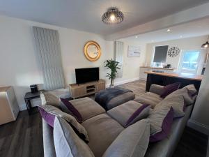 a living room with a large couch and a television at Serene escape in Cleator Moor