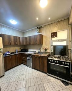 a kitchen with wooden cabinets and a stove top oven at SUNSKY Apartment Hotel in New cairo
