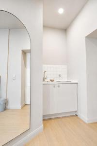 a white kitchen with a mirror in a room at Hotel Schloss Teutschenthal in Teutschenthal