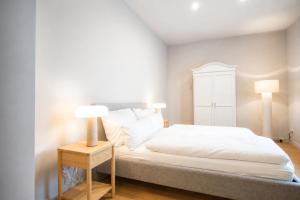 a bedroom with a white bed and two lamps at Hotel Schloss Teutschenthal in Teutschenthal +52 photos