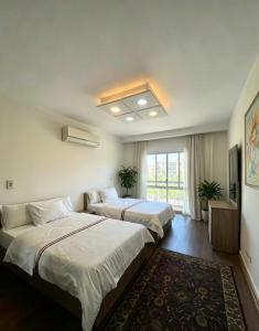 a room with two beds and a television in it at SUNSKY Apartment Hotel in New cairo