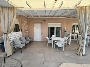 a patio with white tables and chairs and curtains at AVLI Sarti Studios & Apartments no2 in Sarti