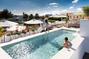 młody chłopiec siedzący w basenie w hotelu w obiekcie Gatzara Suites Santa Gertrudis w mieście Santa Gertrudis de Fruitera