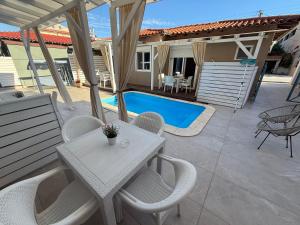 a patio with a table and chairs and a pool at AVLI Sarti Studios & Apartments no2 in Sarti