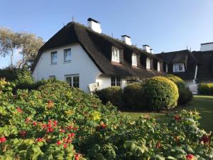 a white house with a thatched roof at Haus Ameland 3e in Wenningstedt
