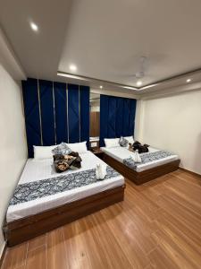 two beds in a room with blue walls and wooden floors at Hotel Royal Suites in Ajmer +49 photos