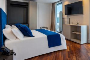 a bedroom with a large bed and a television at Relais Villa Flora Berta in Matelica