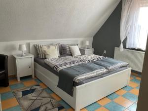 a bedroom with a bed with two night stands and two lamps at Rügen Fewo 307 in Sagard