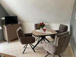a dining room with a table with chairs and a television at Rügen Fewo 307 in Sagard