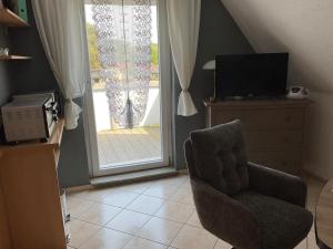a living room with a chair and a television at Rügen Fewo 307 in Sagard +1 photo