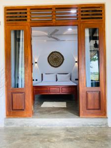 a room with a bed and a glass door at Glossy Lake View in Hambantota