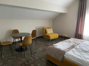 a hotel room with a bed and chairs and a table at Hiking&Ski Hotel in Bukovel